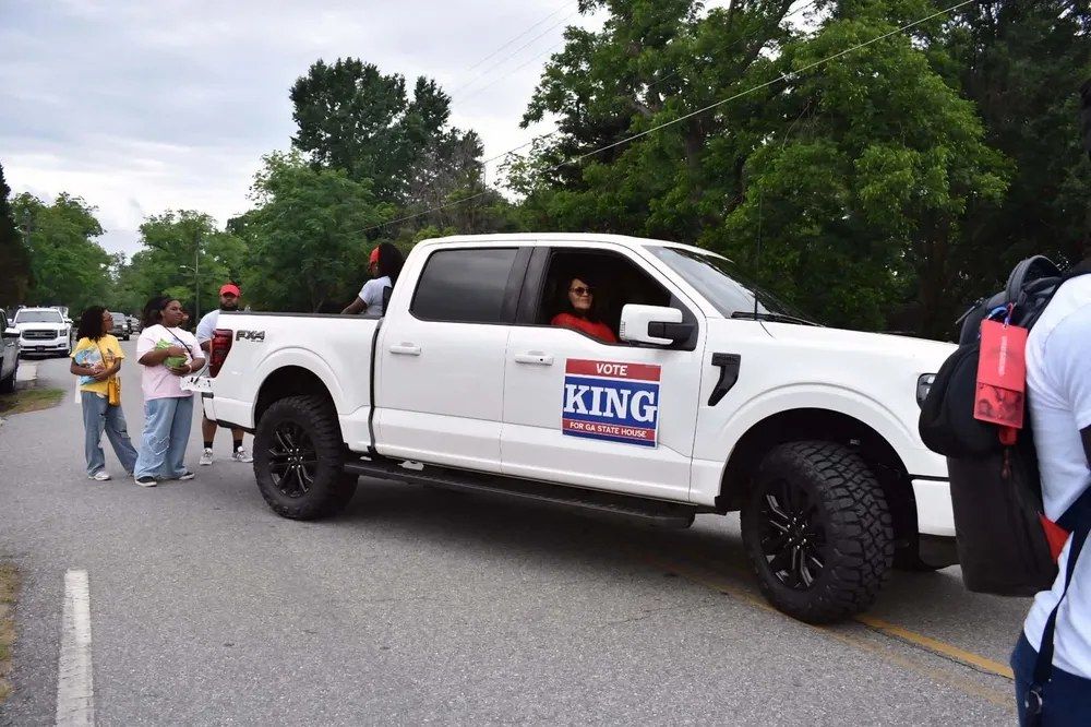 Micah King and campaign volunteers marching with signs